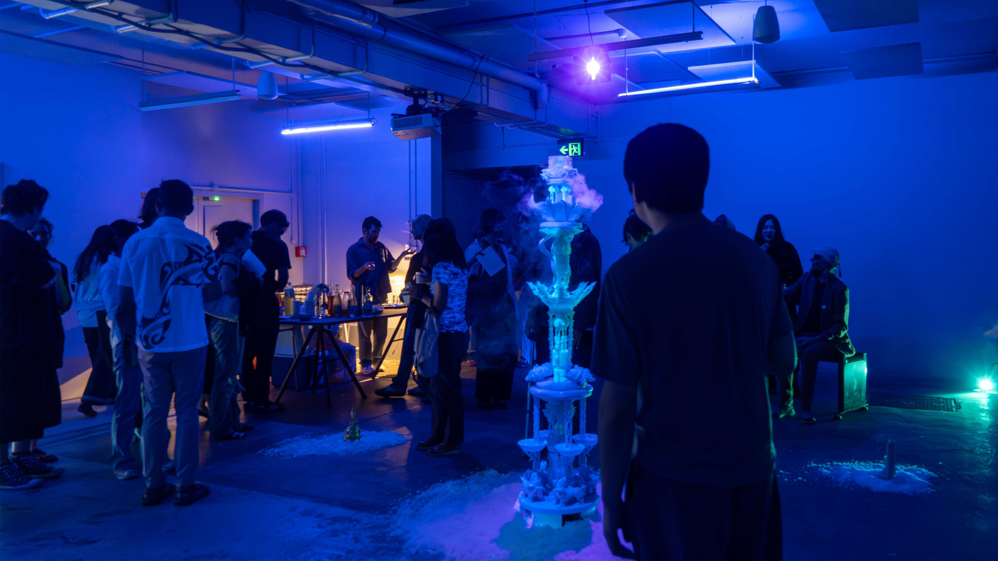 20 people in a dark industrial space standing and talking