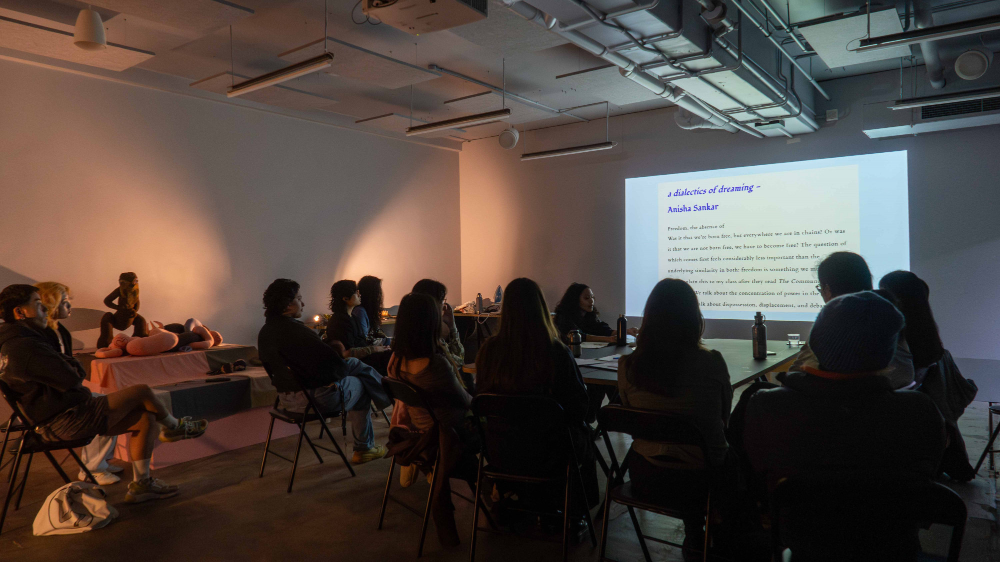 10 people sitting on chairs looking at a powerpoint presentation